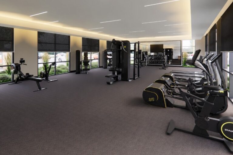 Modern apartment gym with cardio machines, strength equipment, and large windows at the Bob Apartments in Richland, WA