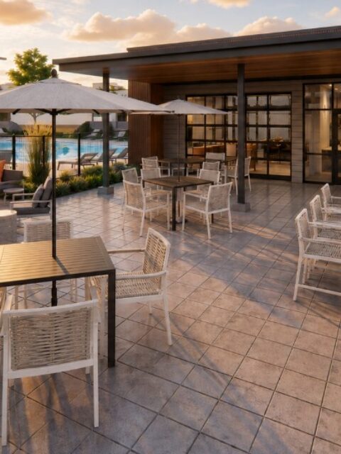 Rooftop lounge at The Bob Apartments with fire pit seating, dining tables, umbrellas, and grills at sunset