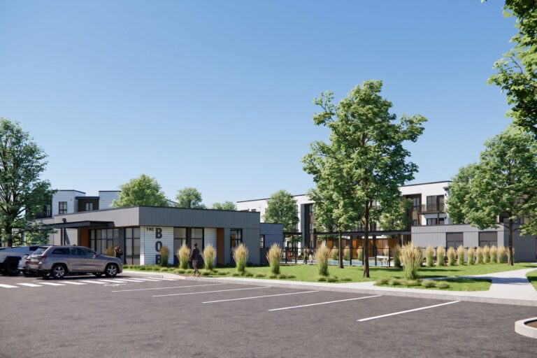 Modern apartment complex with a parking lot, landscaped trees, and a central community building labeled The Bob
