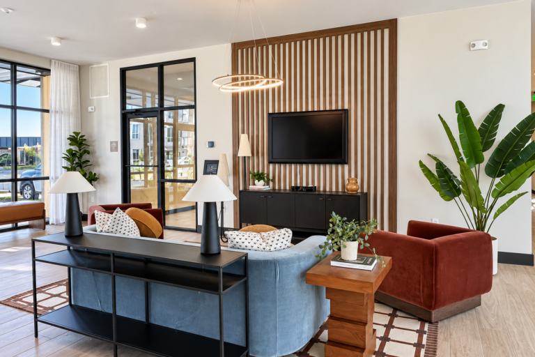 Contemporary Bob Apartments lounge in Richland, WA, with a TV, seating area, plants, and wood-slat accent wall