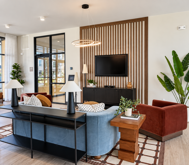 Contemporary Bob Apartments lounge in Richland, WA, with a TV, seating area, plants, and wood-slat accent wall