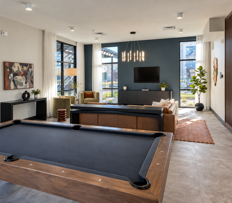Bob Apartments’ modern lounge features a pool table, seating area, wall-mounted TV, large windows, and contemporary furnishings