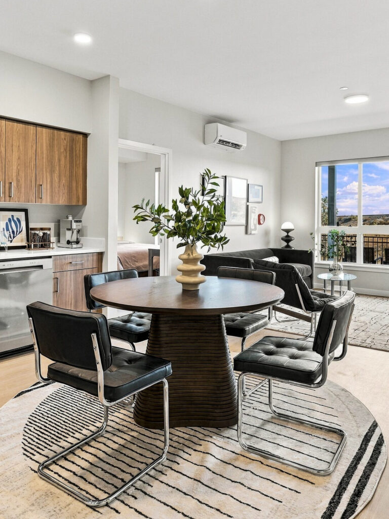 Open-plan Bob Apartments living area in Richland, WA, with a modern kitchen, dining table, seating area, and balcony views