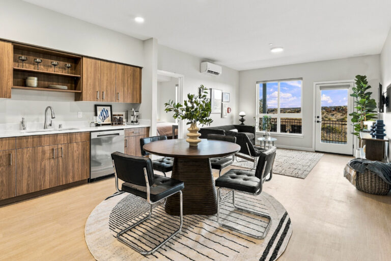 Open-plan Bob Apartments living area in Richland, WA, with a modern kitchen, dining table, seating area, and balcony views
